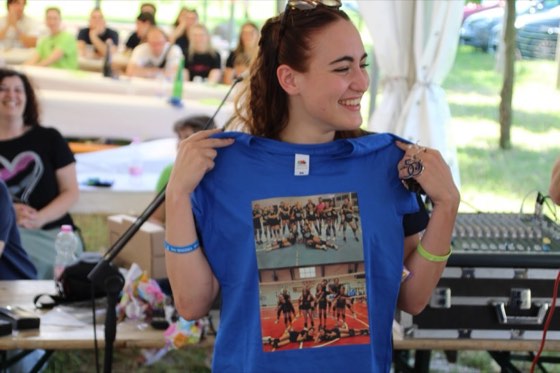 Una ragazza mostra la maglietta celebrativa con le foto delle squadre